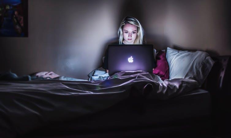 woman with laptop in bed