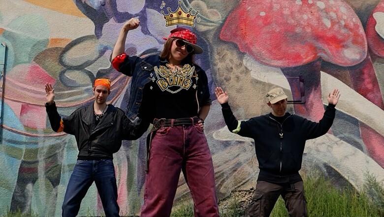 Photo of Tom Allcock, Breanne Allcock, and John Scott in an alley in downtown Calgary, posing against a graffiti wall.