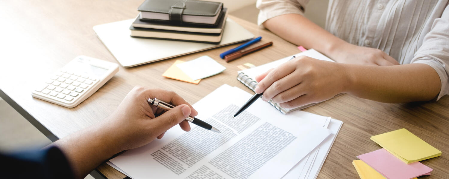 Two hands pointing to documents