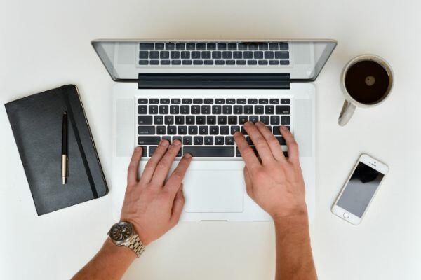 man typing on a laptop