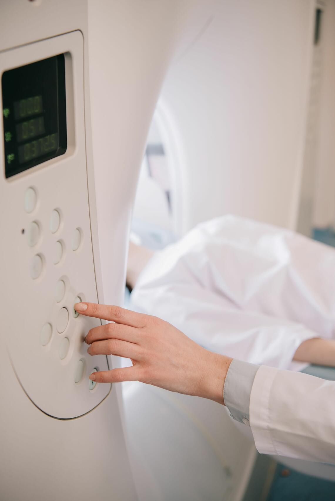 Technician working with patient at MRI machine