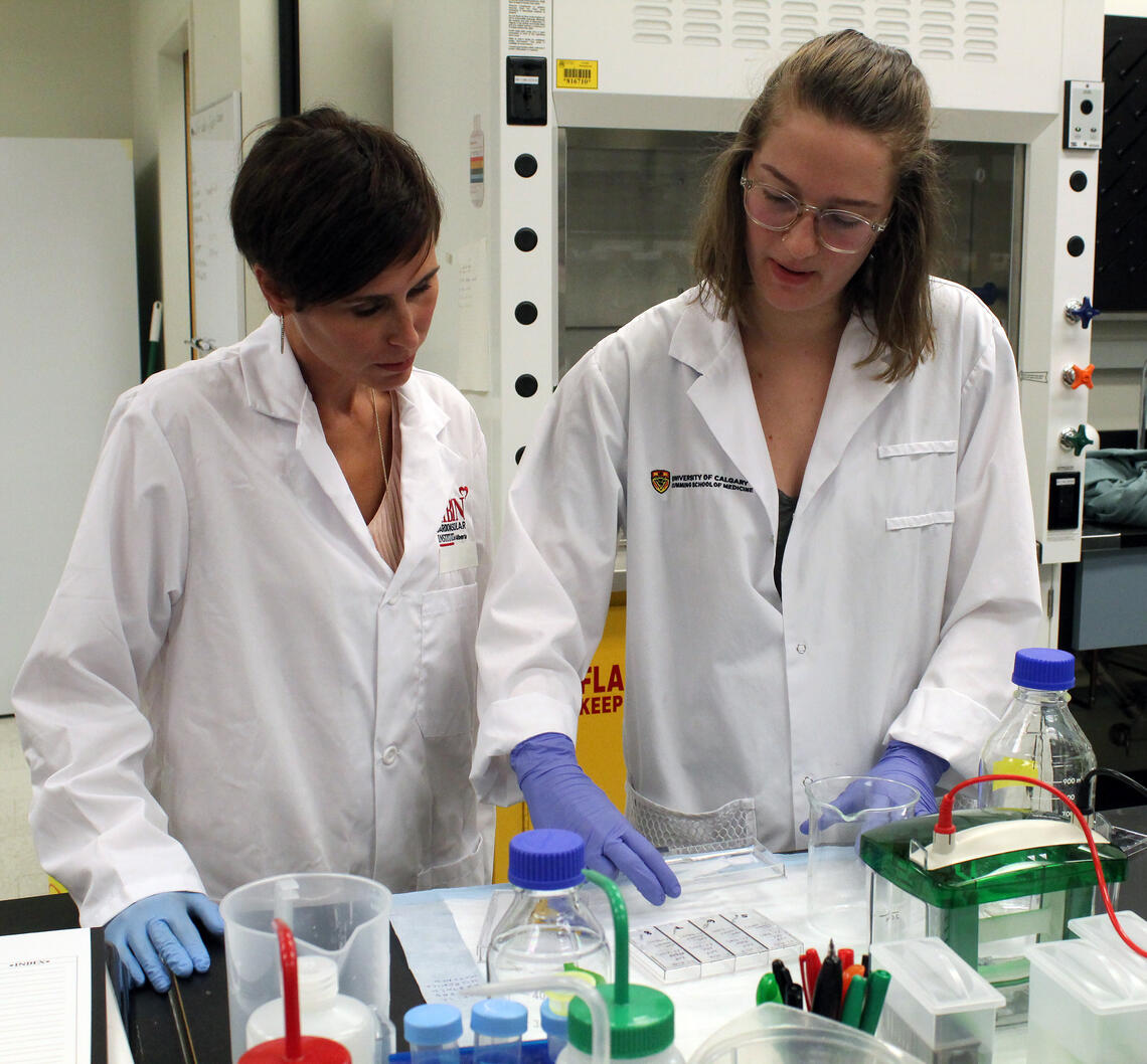 A science student works with her supervisor in the lab