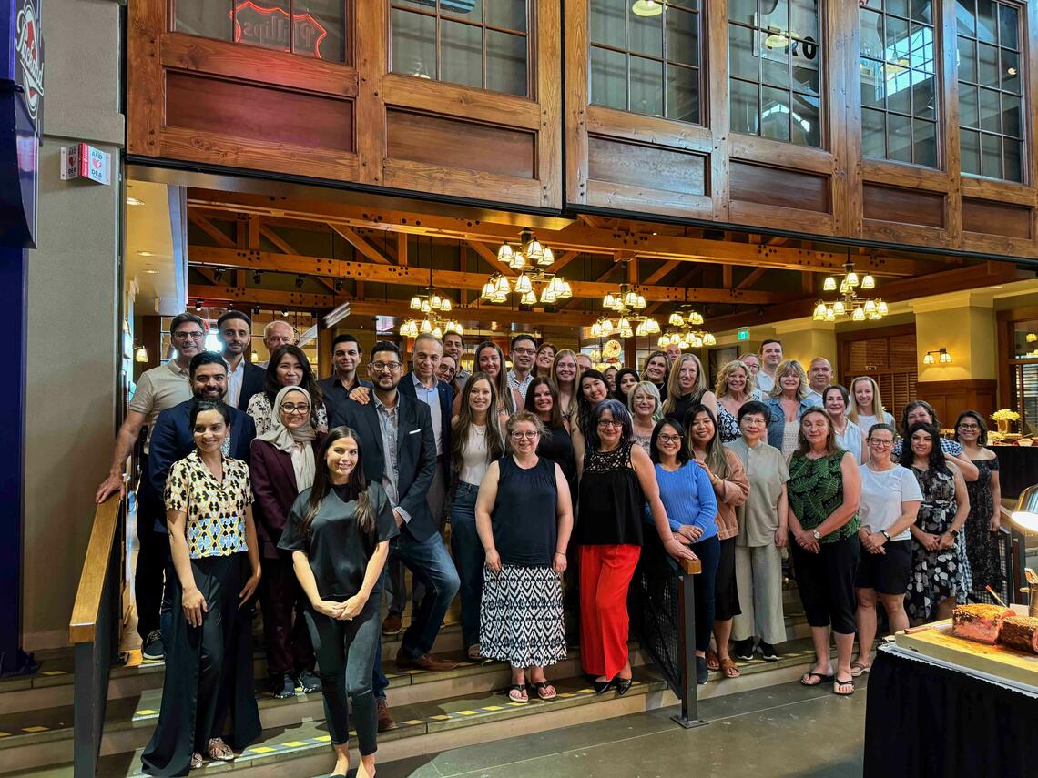  Cath lab physicians, trainees, and allied health members taking a photo together at the annual graduation/cath lab celebration party