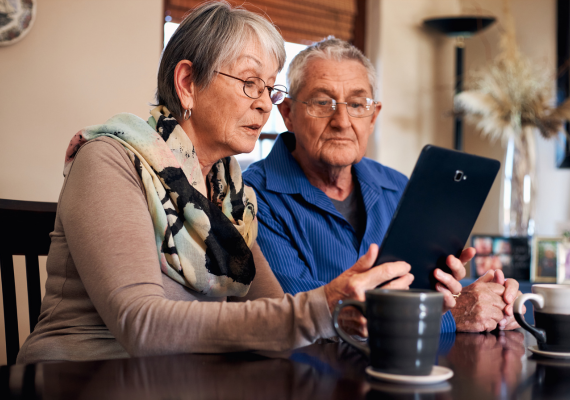 senior couple looking at a tablet