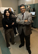 Two scientists stand in front of a tilt table in the autonomic lab