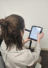 A man sits in front of an Ipad filling out a survey